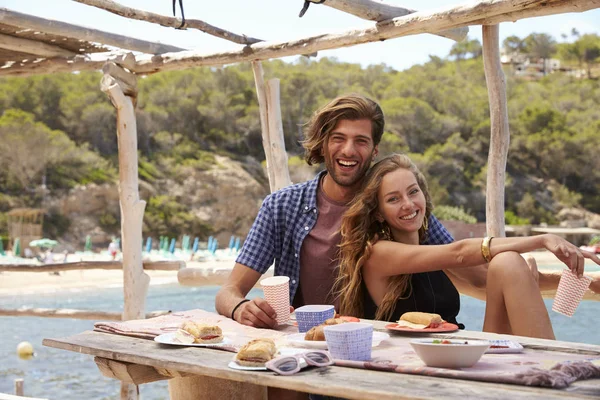 Pareja sentada en una mesa junto al mar —  Fotos de Stock