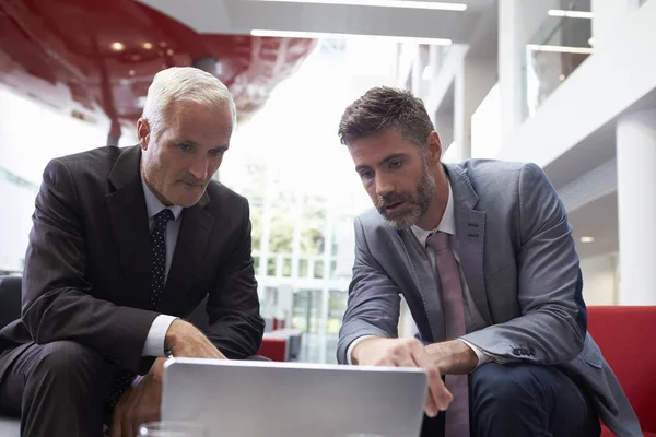 Les hommes d'affaires utilisant l'ordinateur portable dans le hall — Photo