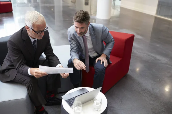 Des hommes d'affaires discutent d'un document dans le hall — Photo