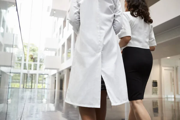 Médicos conversando enquanto caminham no hospital — Fotografia de Stock