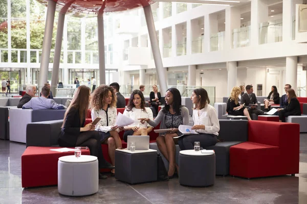 Unternehmerinnen treffen sich in belebter Lobby moderner Büros — Stockfoto