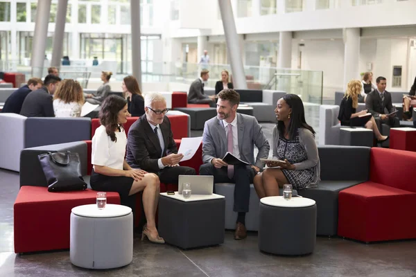 Reunião de empresários no lobby ocupado — Fotografia de Stock