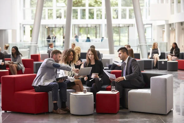 Reunião de empresários no lobby ocupado — Fotografia de Stock