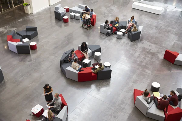 Studenten sitzen in Gruppen in einem Atrium der Universität — Stockfoto