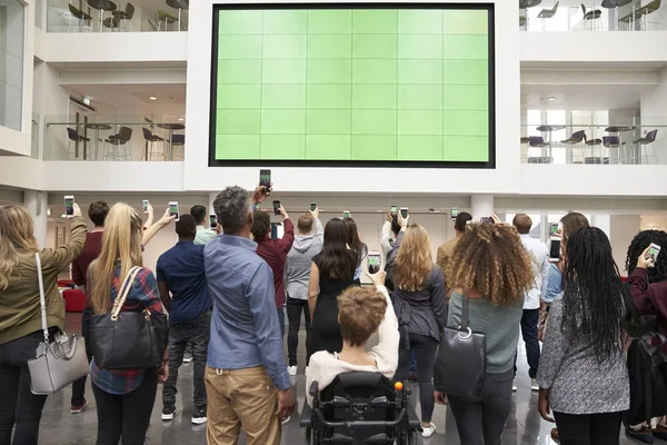 Estudiantes fotografiando pantalla con teléfonos — Foto de Stock