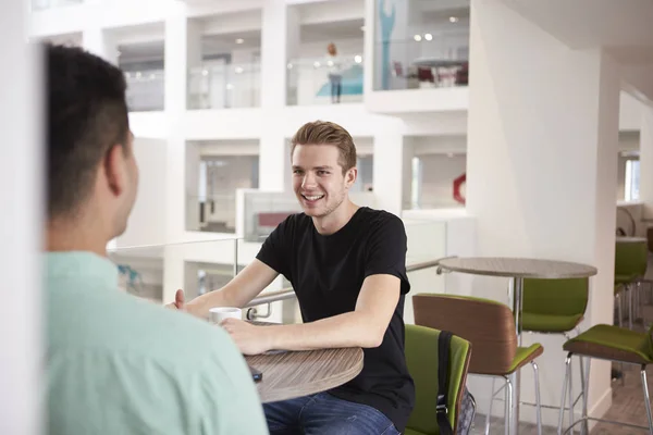 Jonge studenten praten in Universiteit café — Stockfoto