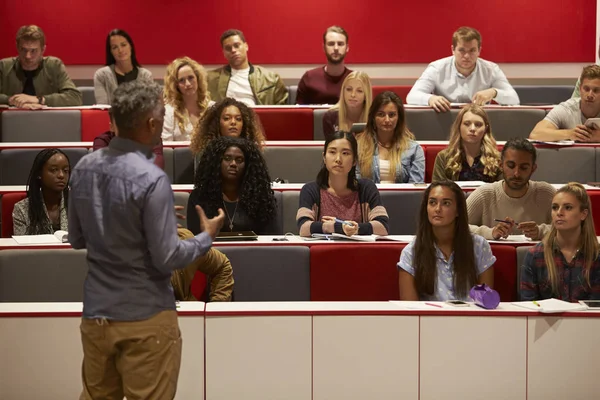Man presenting to students at a lecture theatre — Stock Photo, Image