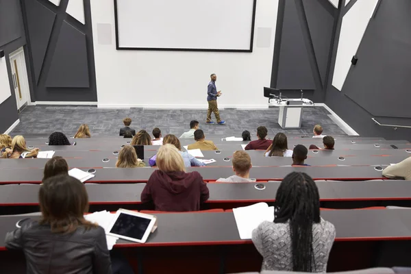 Man lectures students in lecture theatre — Stock Photo, Image