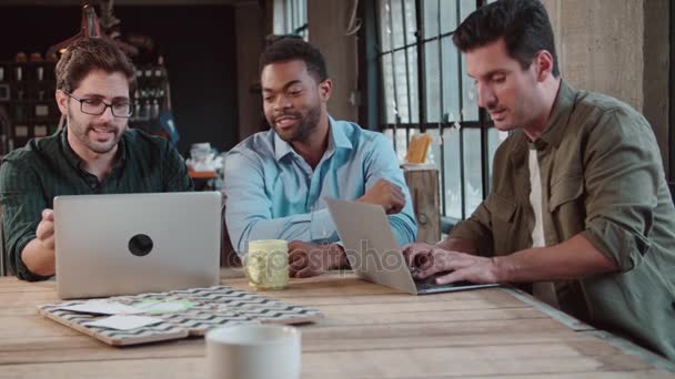 Diseñadores masculinos en reunión usando computadoras portátiles — Vídeos de Stock