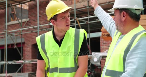 Bouwer op bouwplaats bespreken werk — Stockvideo