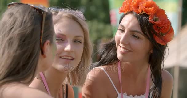 Девушки разговаривают на музыкальном фестивале — стоковое видео