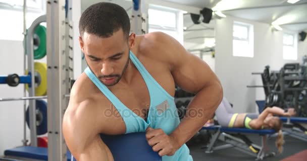 Hombre haciendo ejercicio con la mancuerna en un gimnasio — Vídeo de stock