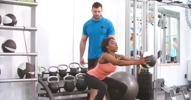 Jeune femme faisant squats dans une salle de gym — Video