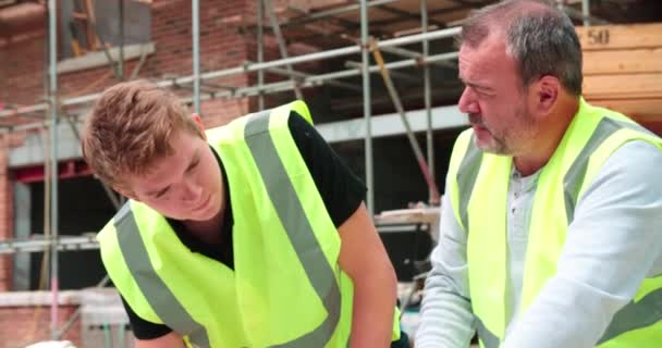 Bouwer op bouwplaats bespreken werk — Stockvideo