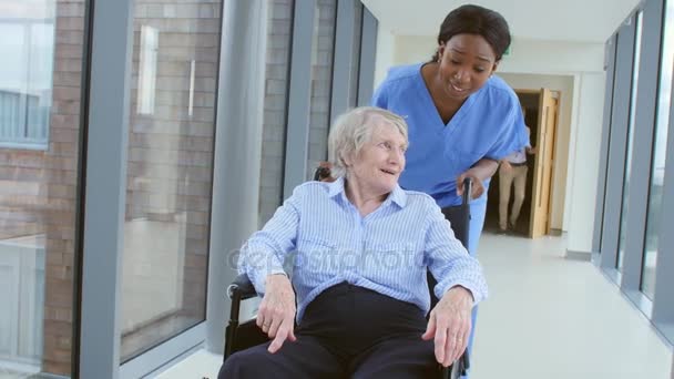Verpleegkundige duwen senior patiënt in rolstoel — Stockvideo