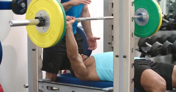 Entraîneur assistant l'homme dans une salle de gym — Video