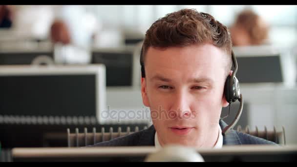 Junger Mann arbeitet in Callcenter — Stockvideo