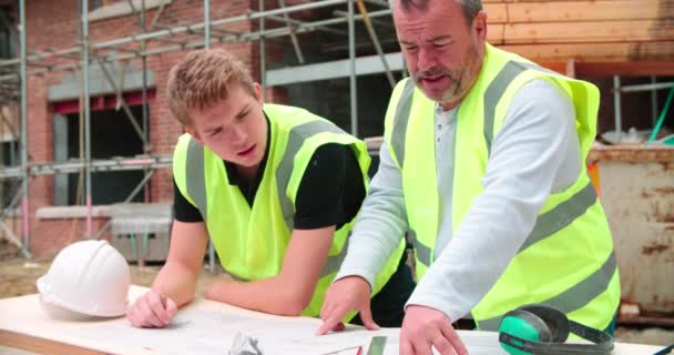 Byggaren på byggnadsplatsen diskuterar arbete — Stockvideo