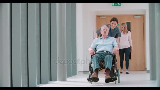 Медсестра толкает пожилого пациента в инвалидном кресле — стоковое видео