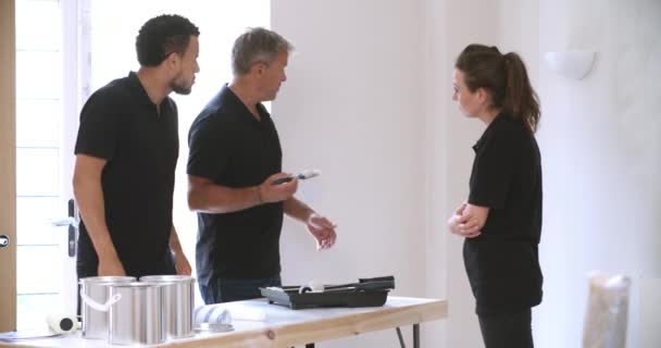 Decorador instruyendo a jóvenes colegas de pintura — Vídeos de Stock