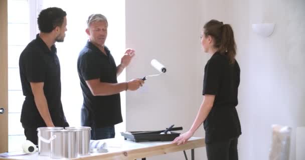 Decorator instructing colleagues painting — Stock Video