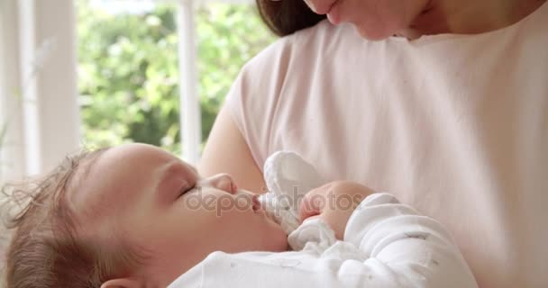 Мать целует спящего ребенка — стоковое видео