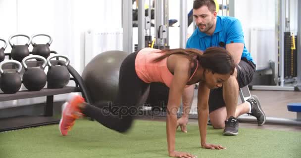 Jonge vrouw aan het sporten in de sportschool — Stockvideo