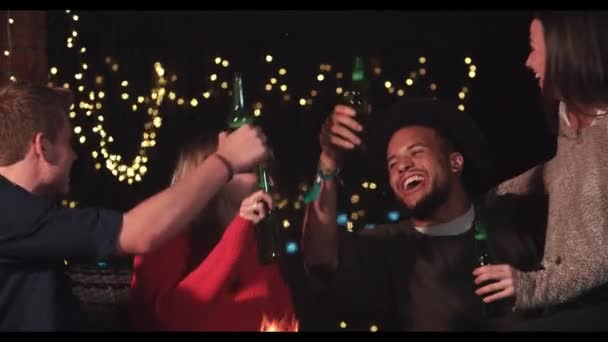 Przyjaciół ciesząc się wieczorne drinki przez paleniska — Wideo stockowe