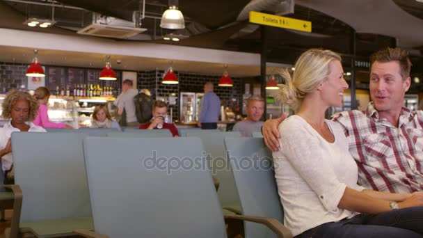 Ζευγάρι που σας περιμένει στο χώρο αναμονής του αεροδρομίου αναχώρησης — Αρχείο Βίντεο