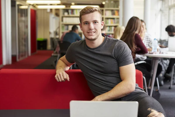 Studente di sesso maschile che lavora in biblioteca — Foto Stock