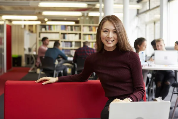 Vrouwelijke student werkzaam in bibliotheek — Stockfoto