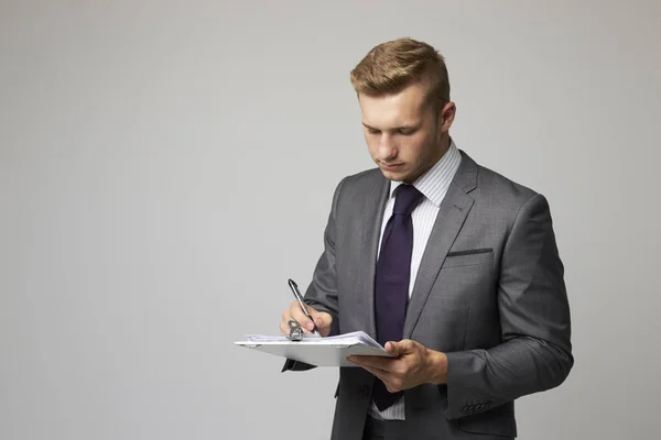 Empresario escribiendo en portapapeles —  Fotos de Stock