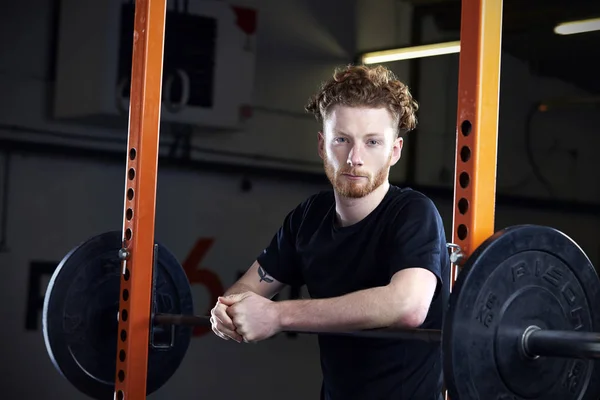 Hombre en el gimnasio descansando durante el entrenamiento — Foto de Stock