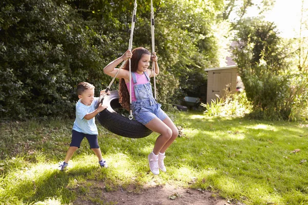 Flicka spela på däck Swing med pojke — Stockfoto