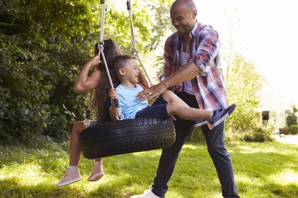 Pai e filhos no balanço de pneu — Fotografia de Stock