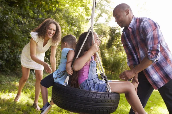 Padres e hijos en el columpio de neumáticos — Foto de Stock
