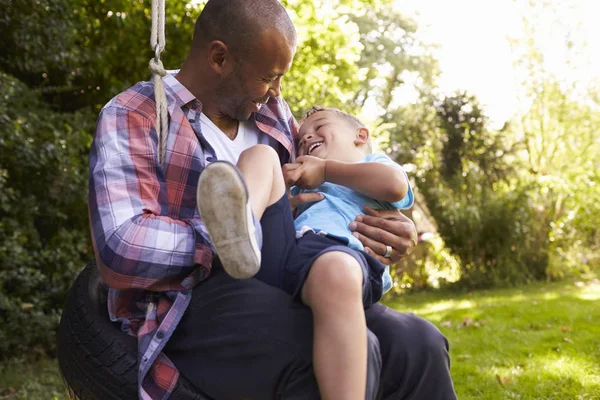 Padre e figlio su pneumatico swing — Foto Stock