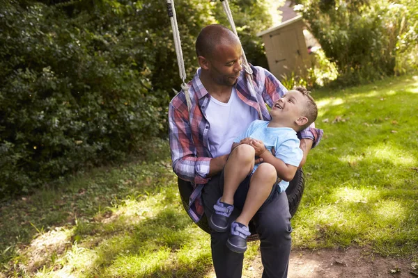 Pai e filho no balanço de pneu — Fotografia de Stock