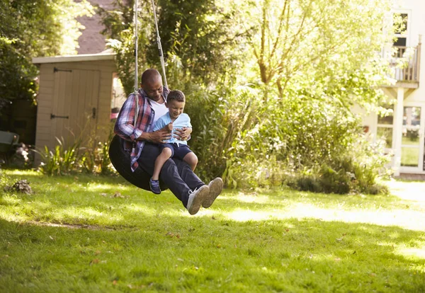 Vater und Sohn auf Reifenschaukel — Stockfoto