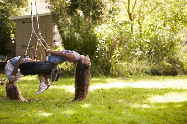 Due ragazze giocare su pneumatico swing — Foto Stock