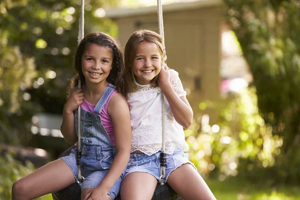 Üzerine lastik salıncak oturan iki kız — Stok fotoğraf