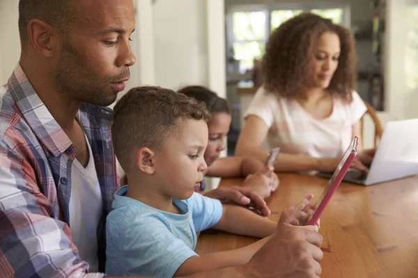 Família usando diferentes gadgets digitais — Fotografia de Stock