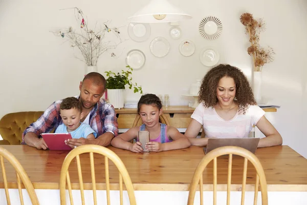 Familia usando diferentes aparatos digitales — Foto de Stock