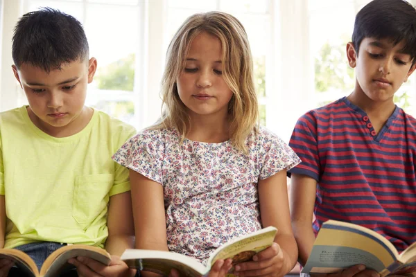 Niños leyendo en el asiento de la ventana —  Fotos de Stock