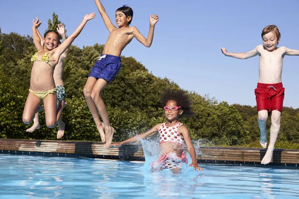 Lapset hyppäävät uima-altaaseen — kuvapankkivalokuva