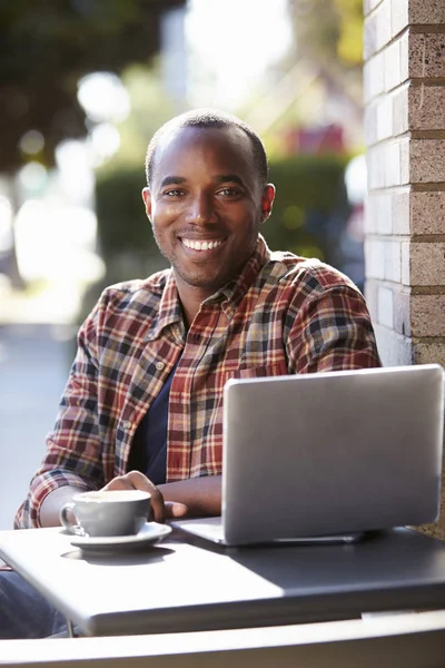 Man with laptop looking at camera — Stock Photo, Image