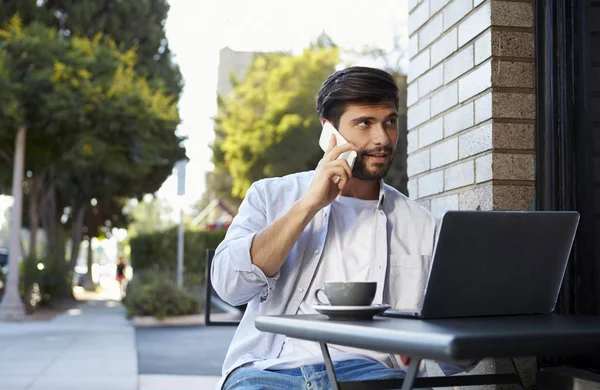 Мужчина с ноутбуком говорит по телефону — стоковое фото
