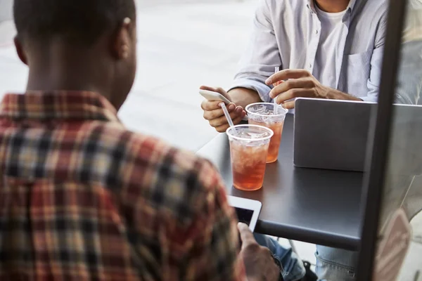 Amigos con aparatos electrónicos en la cafetería —  Fotos de Stock