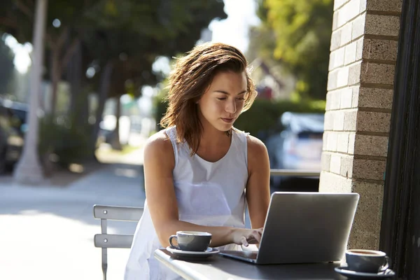 Woman using laptop at cafe — Stock Photo, Image