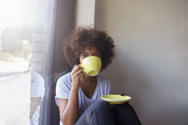 Jonge vrouw zitten en koffie drinken — Stockfoto